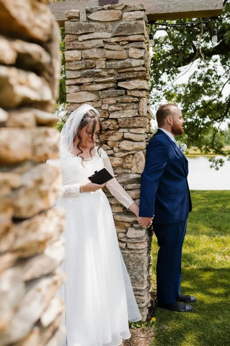 Bride and groom first look stone pillar holding hands outdoor wedding Oklahoma
