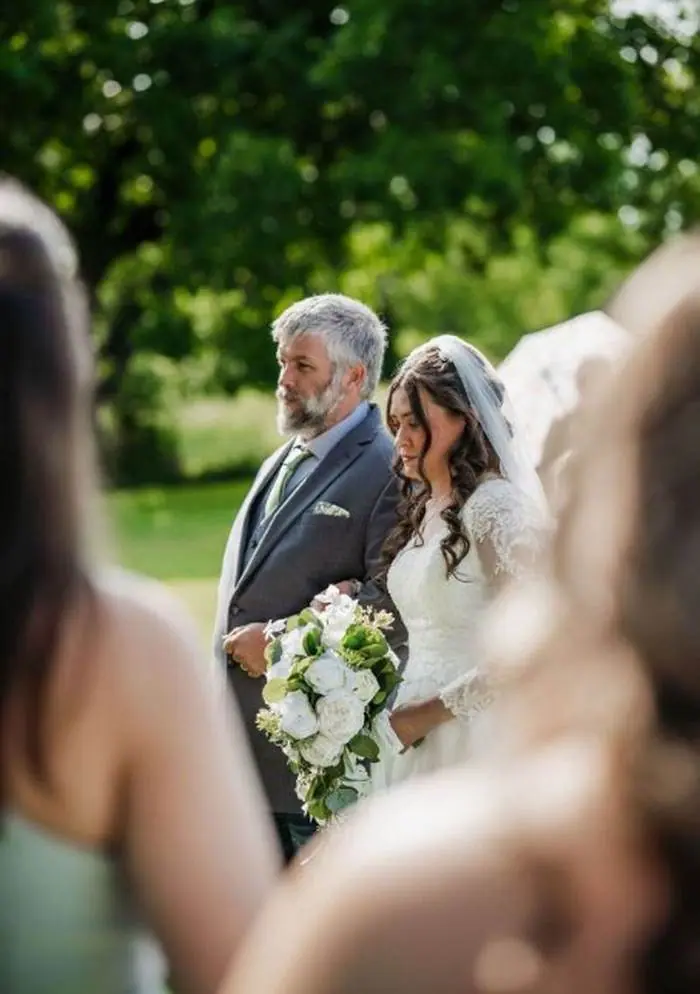 Bride walking down aisle with father outdoor ceremony green trees Oklahoma wedding