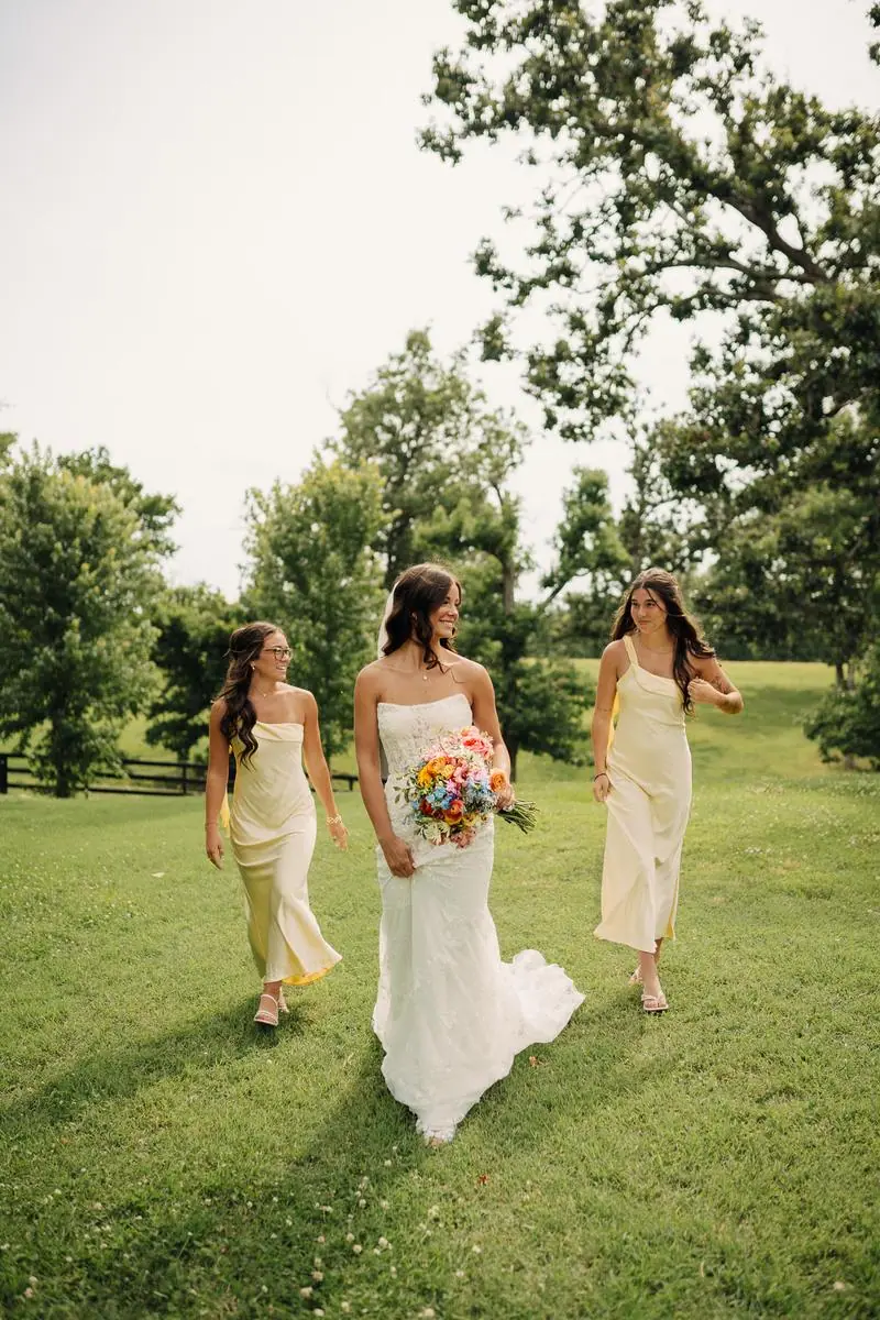 Bride with bridesmaids in yellow dresses walking outdoor Oklahoma wedding photography