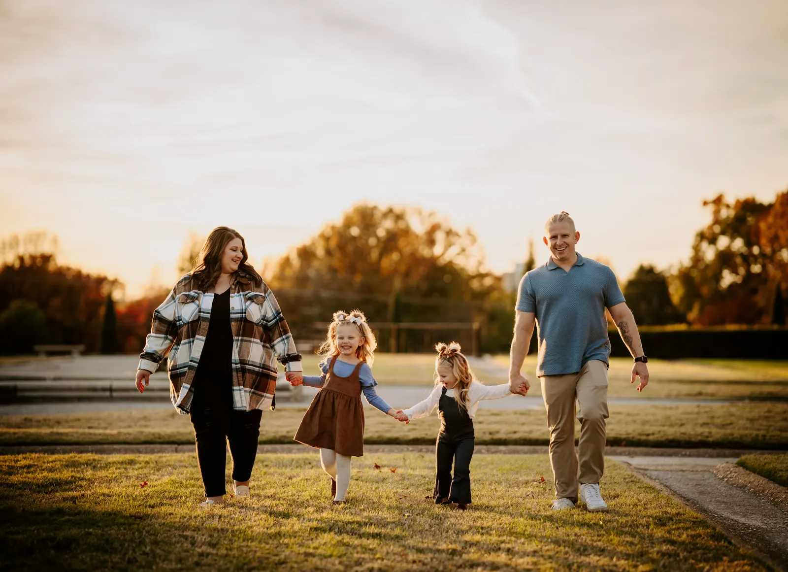 Family of four walking holding hands golden hour Oklahoma family photography