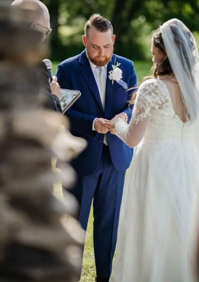 Groom placing ring on bride finger outdoor ceremony wedding photographer Oklahoma