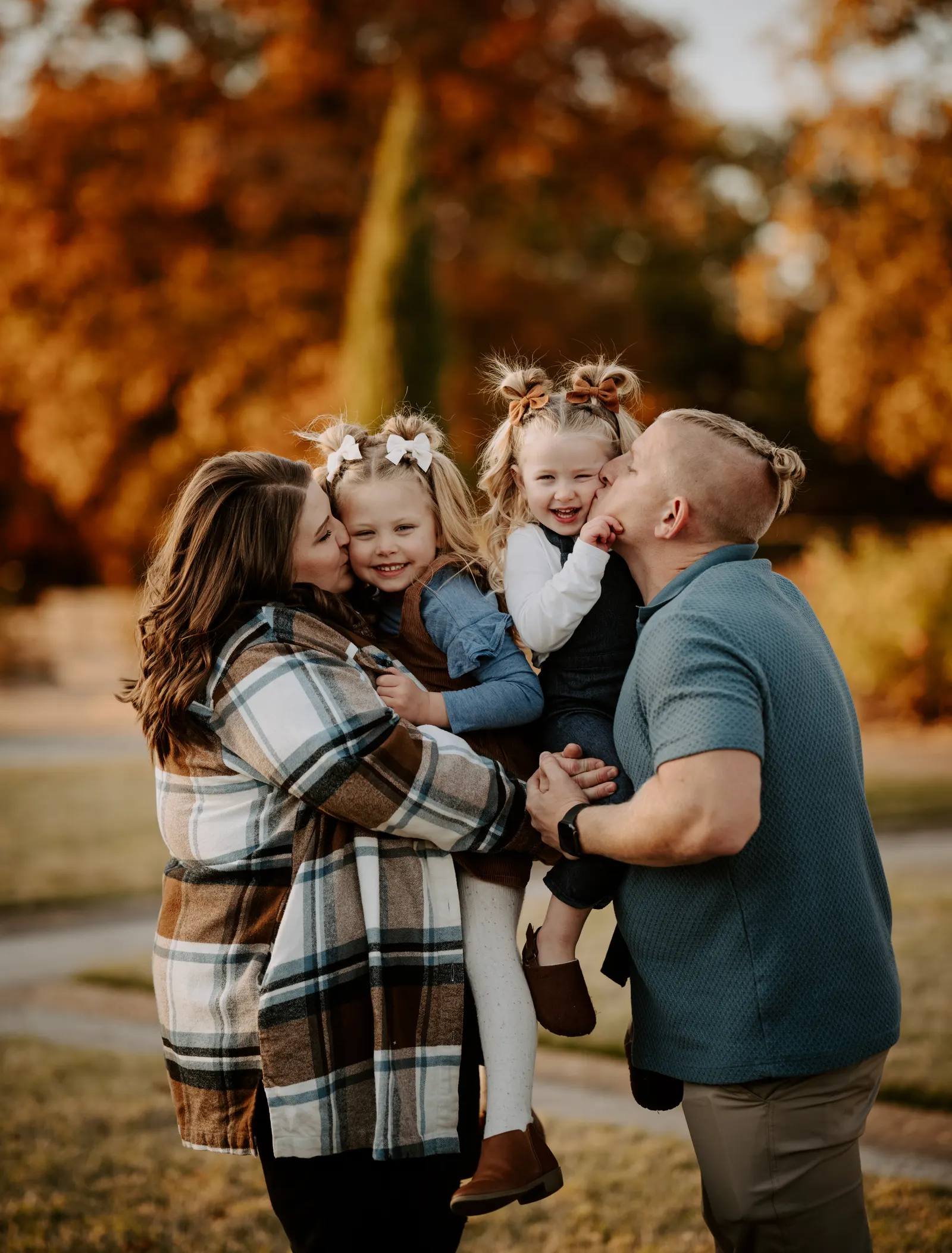 Parents kissing daughters cheeks family session Oklahoma