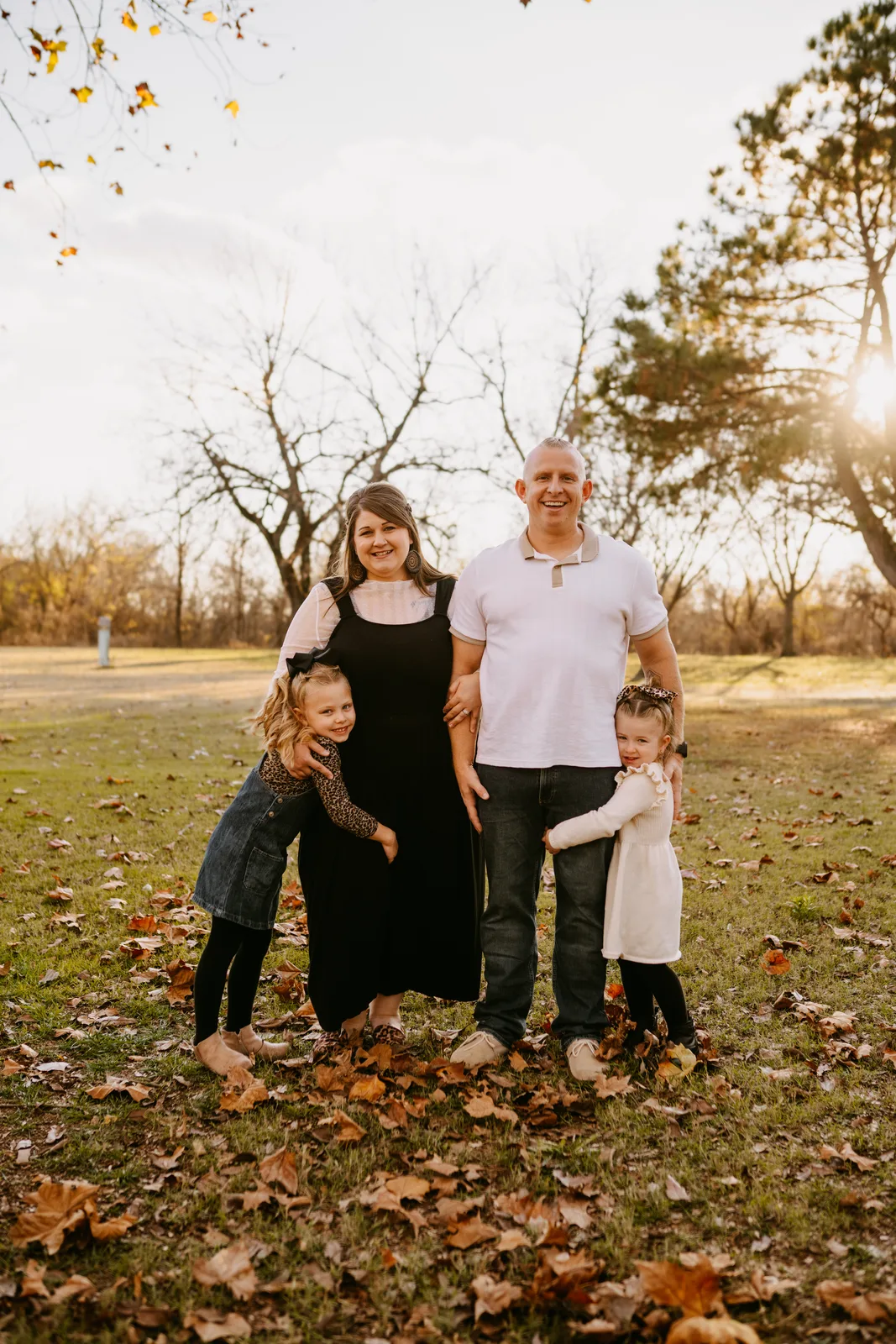 Parents with two daughters autumn leaves family session Oklahoma